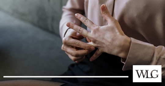 Person removing a ring from their ring finger.
