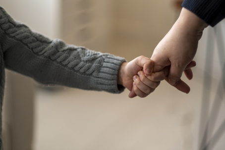 small child holding on to parent's finger
