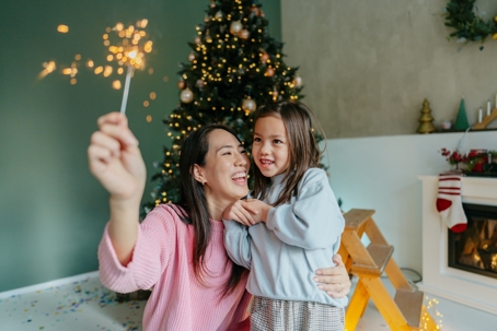 mother and daughter playing with sparklers during the holidays