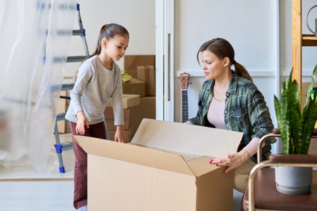 mother and daughter packing up moving boxes