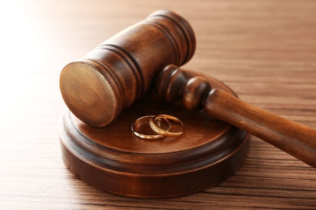 Golden wedding rings with judge gavel, closeup